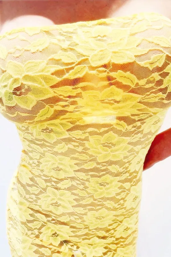 Annaliese showing off her bust in a yellow dress close up
